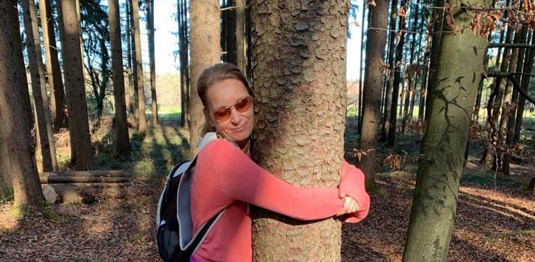 Schon mal einen Baum umarmt? Schon mal einen Baum umarmt? Claudia Mitchell umarmt achtsam einen Baum im Wald.