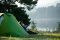 Camping am See Camping am See: Ein Mann sitzt vor seinem Zelt an einem See.