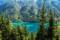 Weissensee mit türkisblauen Wasser vor Kulisse mit Wäldern in Österreich