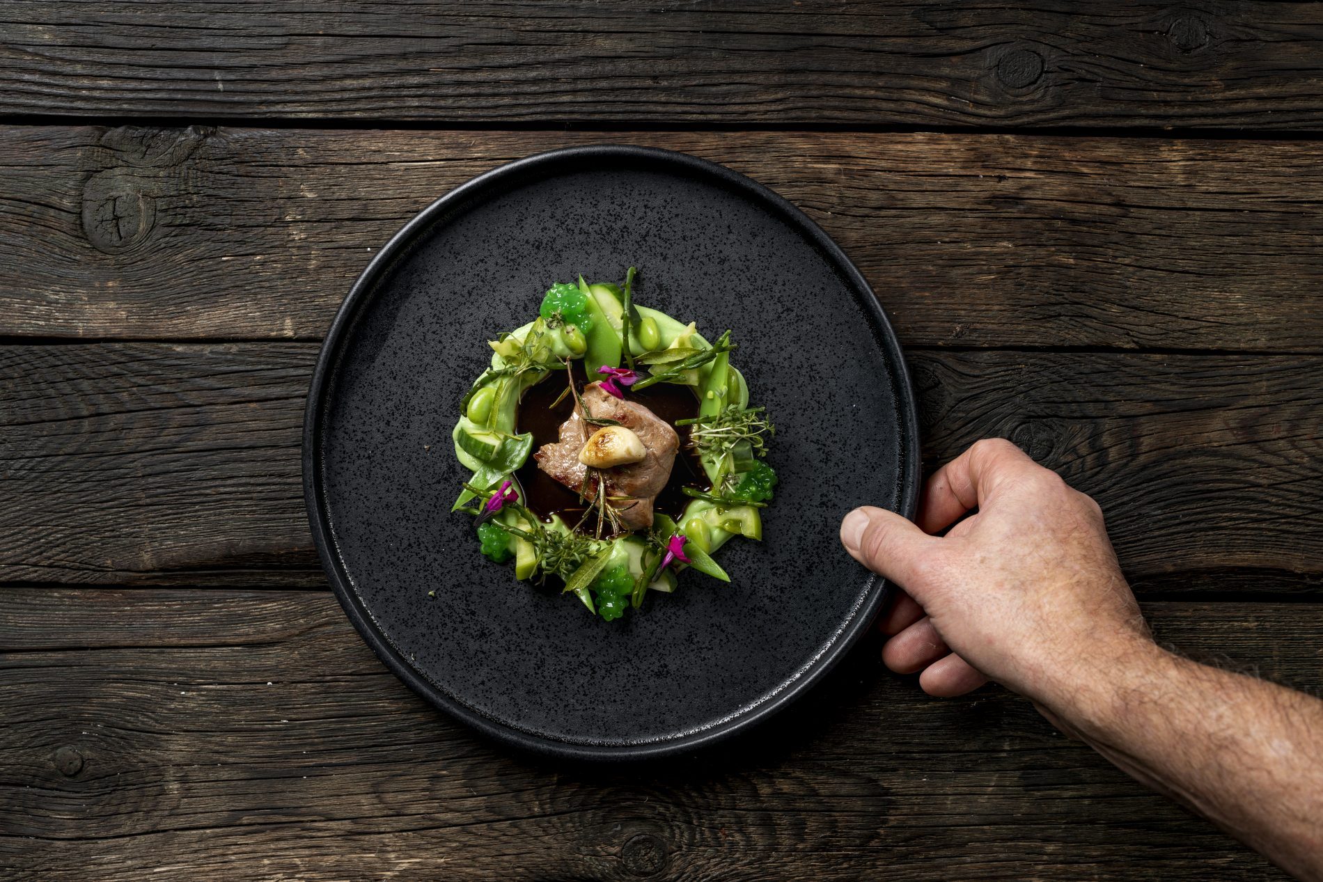 Lammfleisch mit Bohnenpüree auf dunklem Teller