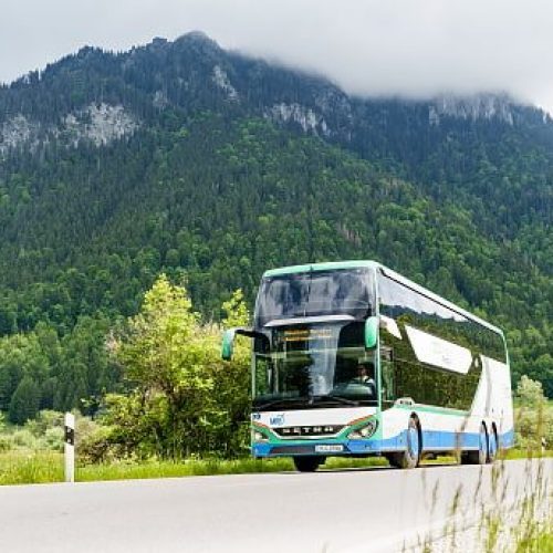Ein Bergbus auf der Straße mit Bergen im Hintergrund