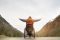 Barrierefreier Urlaub in Bayern: Eine Person im Rollstuhl steht auf einem Weg in der Natur und breitet ihre Arme weit aus.