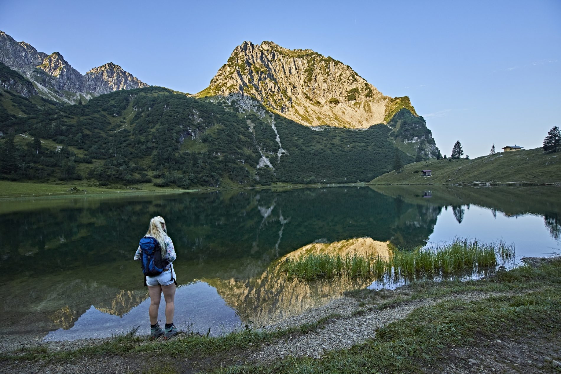Unterer Gaisalpsee © erlebe.bayern – Gert Krautbauer Eine Frau steht vorm Unteren Gaisalpsee. Die Bergspitzen werden von der Sonne angestrahlt.