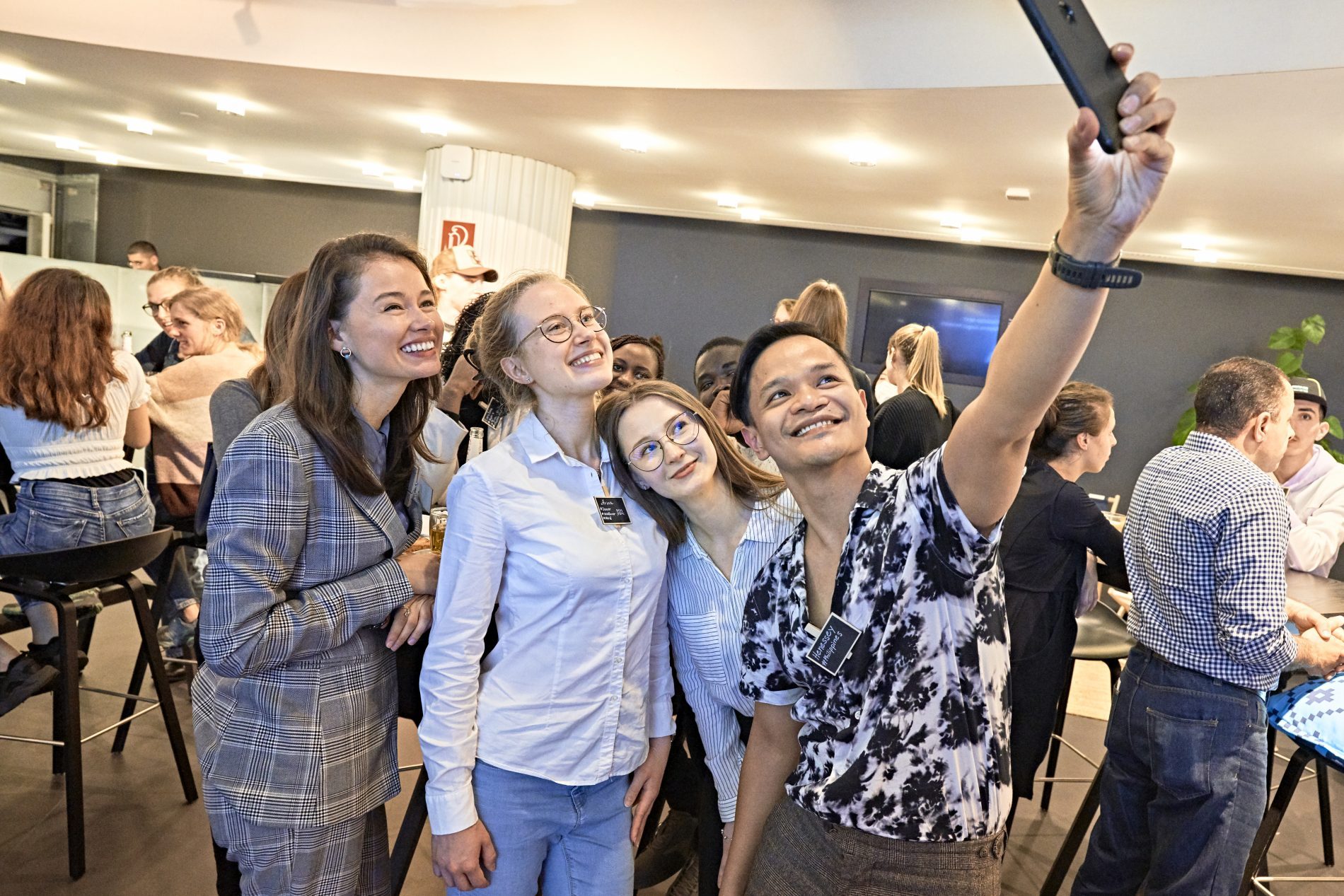Eine Gruppe aus 4 jungen Touristiker*innen macht ein Selfie bei der Veranstaltung "Tourism Next - Bayerns junges Netzwerk".