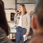 Sophia Buckl mit einem Mikrofon in der Hand bei der Moderation von "Tourism Next - Bayerns junges Netzwerk"