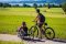 Rad_AP_2021_1(27) Handbikerin und Fahrradfahrerin auf einem Radweg vor Bergkulisse
