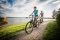 Zwei Radfahrer (Frau und Mann) fahren am Steinberger See Ufer entlang