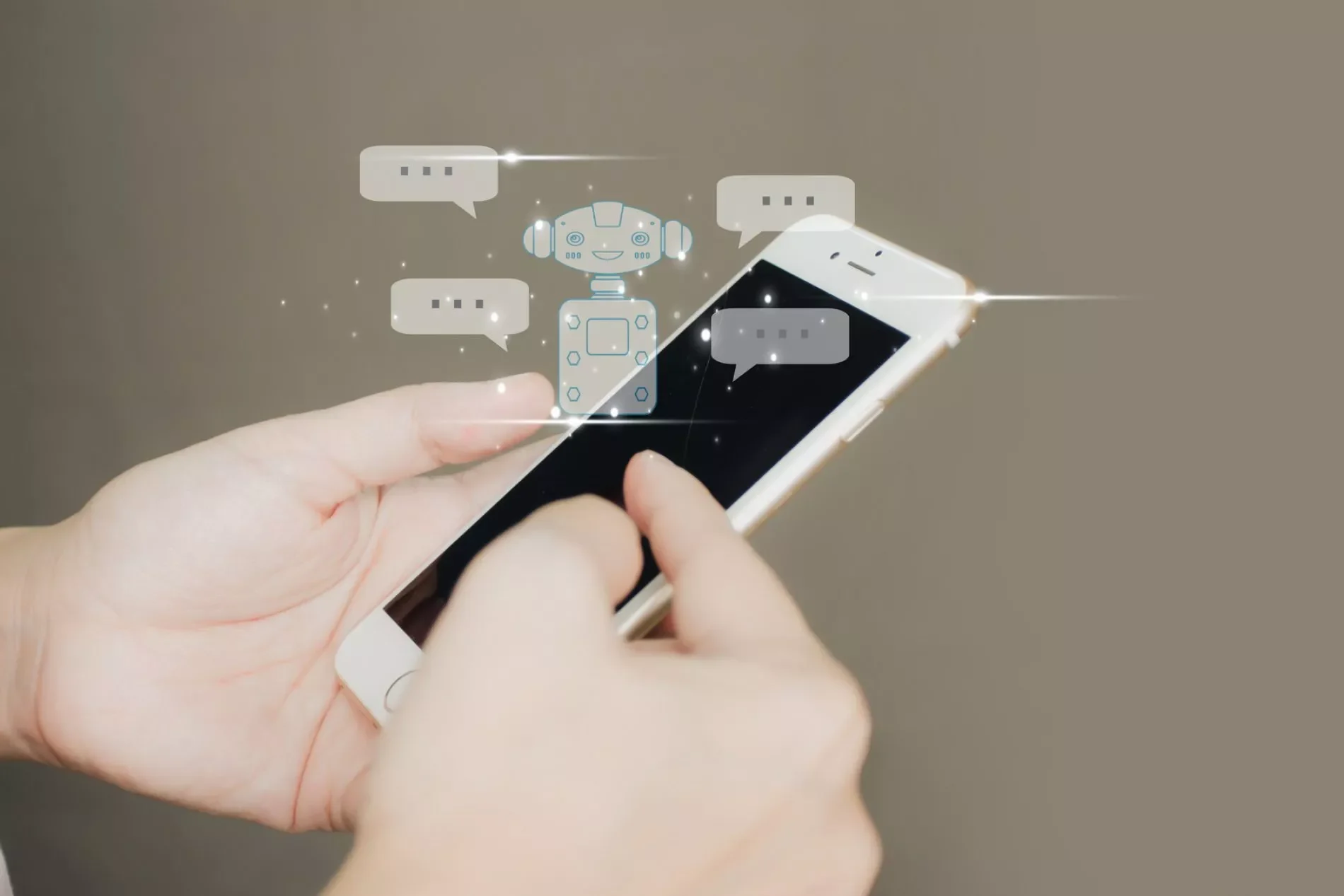 TC-Content-Creator-1900×1267.jpg Hände halten ein Smartphone; über dem Bildschirm schwebt ein Roboter-Icon mit Chatblasen, Symbol für Content Creation.