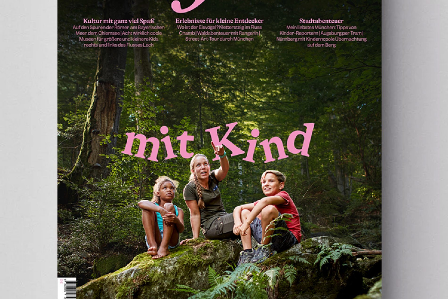 Cover des Magazins Bayern, Familienmagazin Grau: Drei Kinder sitzen auf einem Felsen im Wald; pinke Schrift Bayern oben.