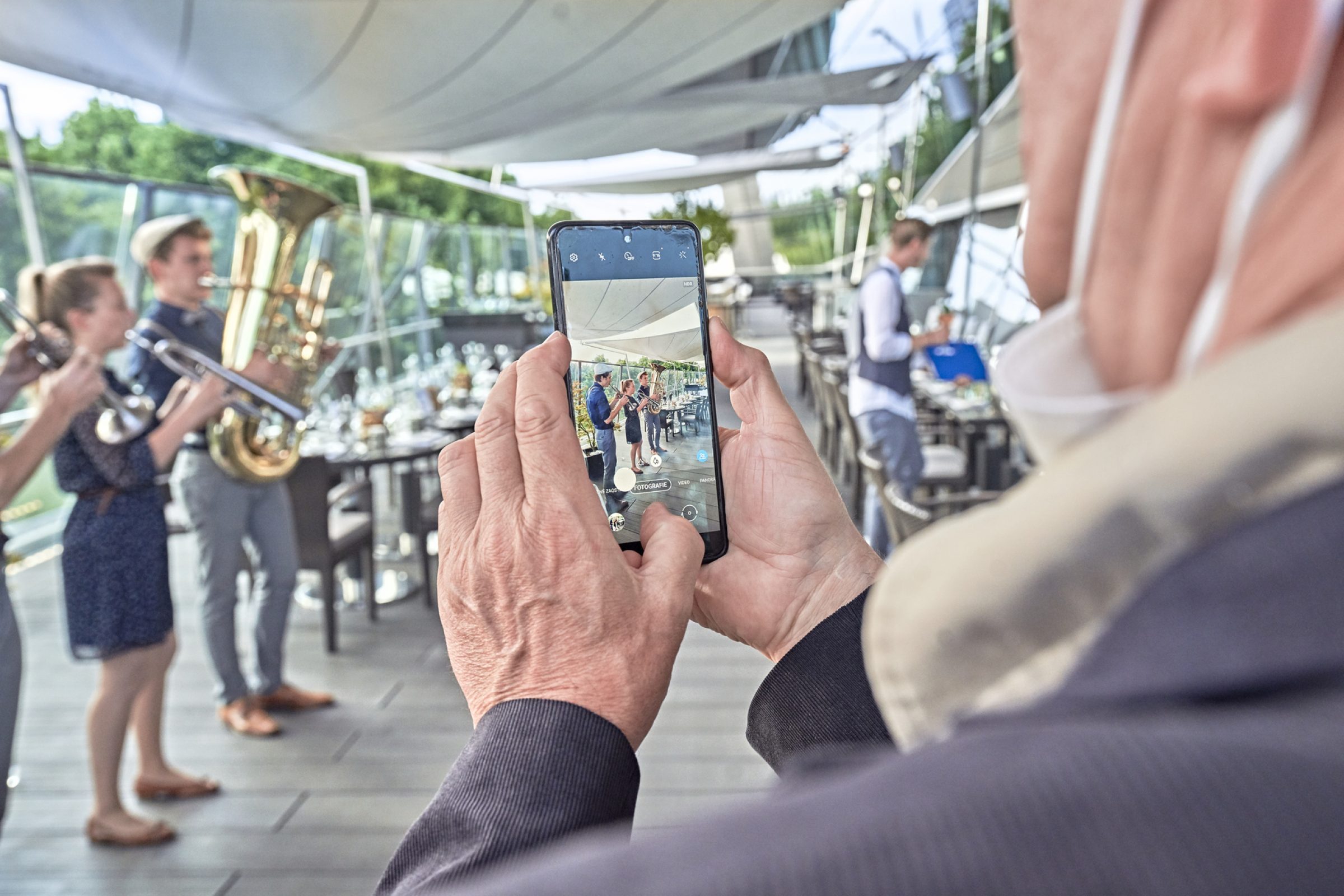 Person filmt Bl&auml;sergruppe mit Smartphone w&auml;hrend des DriveBay Workshop 2021 auf einem Boot