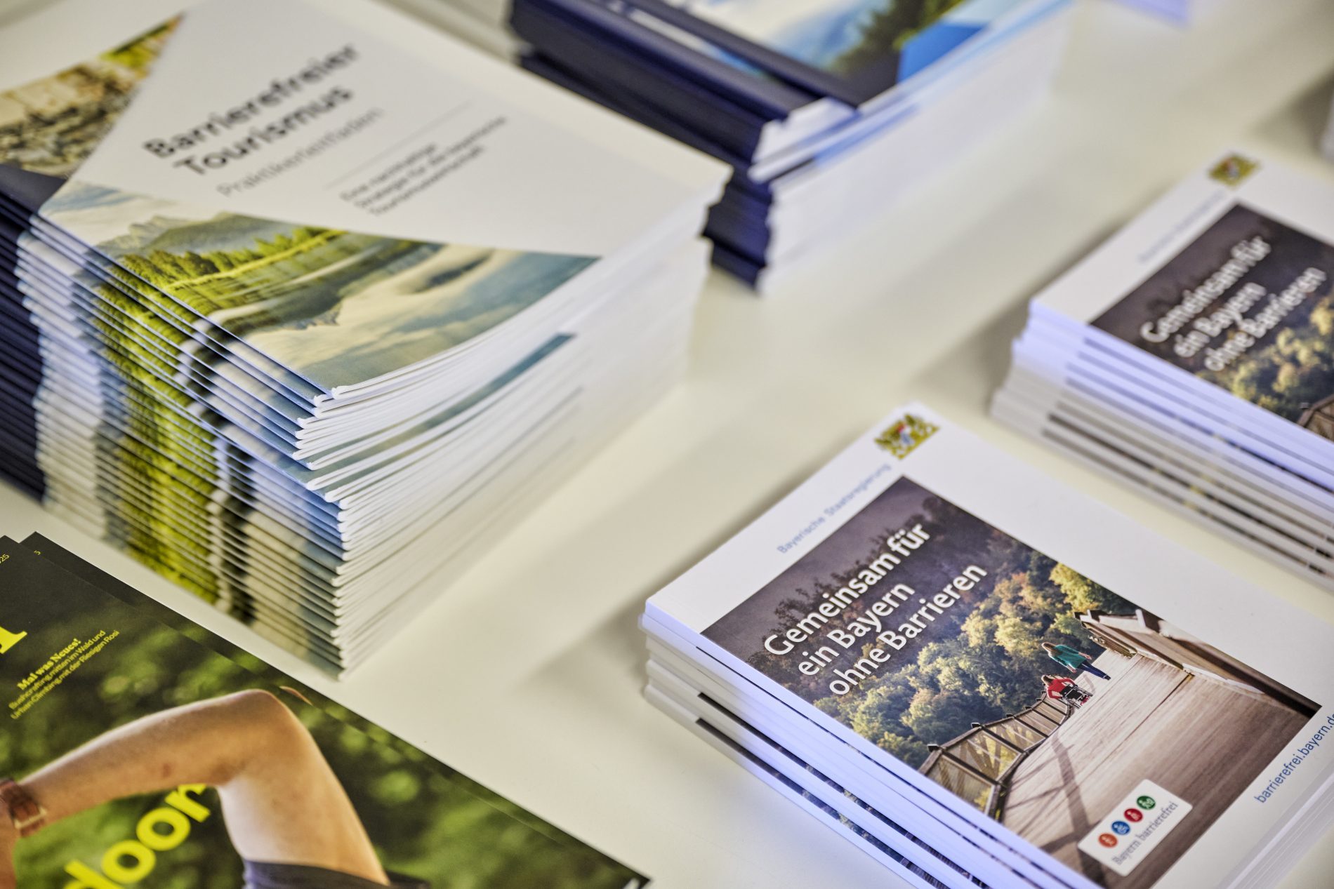Stapel Broschüren mit Titeln Barrierefreier Tourismus und Gemeinsam für ein Bayern ohne Barrieren