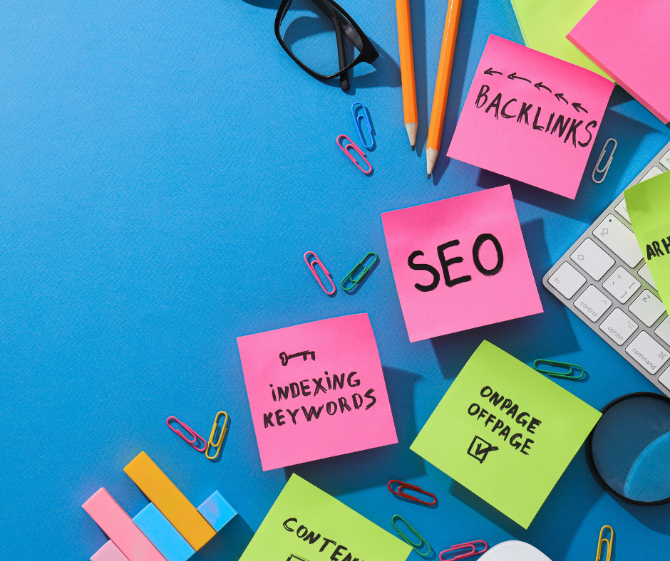 SEO-Strategie-Konzept mit bunten Haftnotizen auf blauem Hintergrund. Notizen mit Begriffen wie 'SEO', 'Backlinks', 'Indexing Keywords' und 'Onpage Offpage' sind umgeben von Büroartikeln wie Stiften, Büroklammern und einer Tastatur.