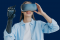 Eine Frau mit einer Armprothese trägt eine Virtual-Reality-Brille und hebt die Hand, als ob sie in der virtuellen Umgebung interagiert.