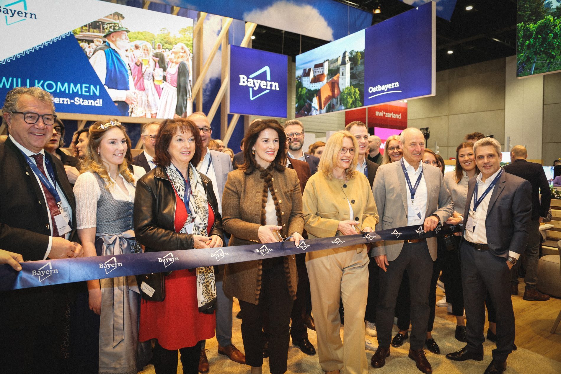 Gruppe von Delegierten und Gästen schneidet am Bayern-Stand das Band bei der ITB Berlin 2025 durch.