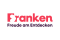 Logo des Tourismusverbands Franken: rote Bergsilhouette über dunklem Untergrund, Symbol für Freude am Entdecken.