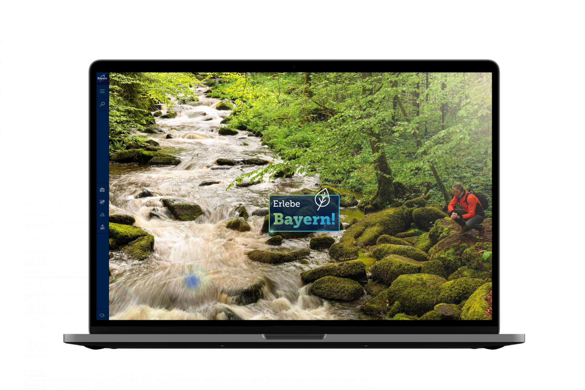 Startseite von erlebe.bayern Laptop-Display zeigt Waldfluss mit Moossteinen und rechts sitzender Wanderperson; Logo Erlebe Bayern.