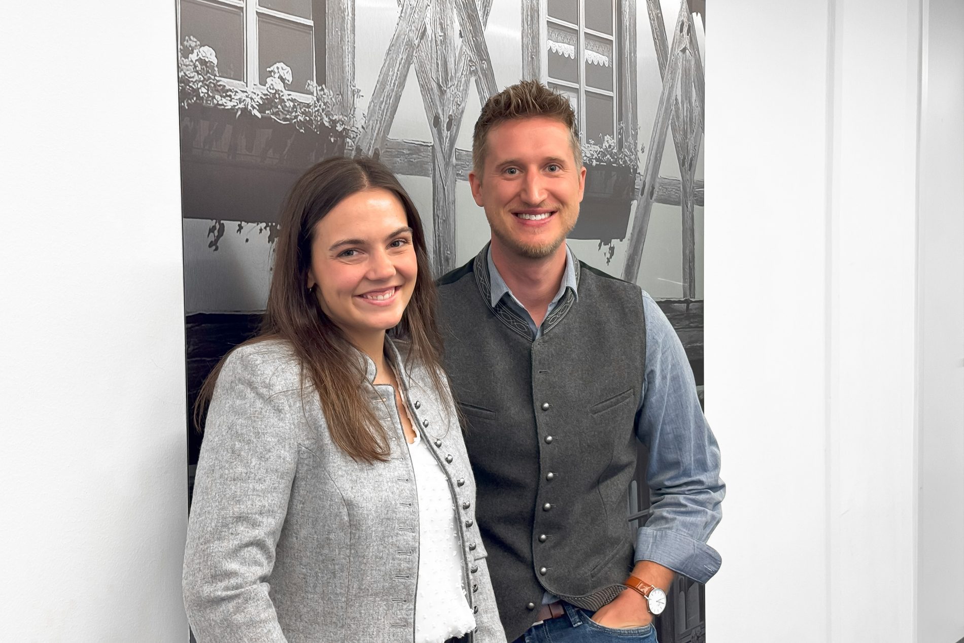 Zwei l&auml;chelnde Personen vor Hintergrundbild; Team TTR, Bayern Workshop 2026 &ndash; MICE & Trade.
