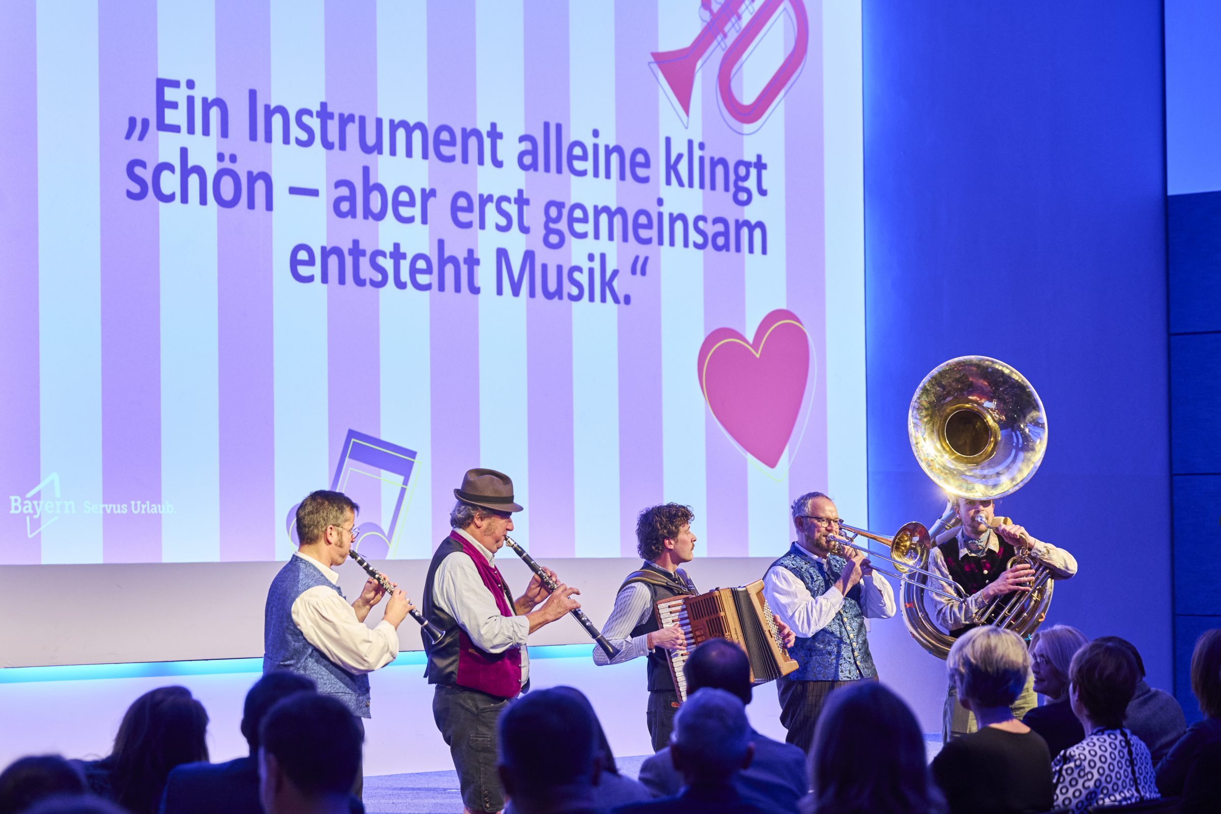 Musikanten spielen Musik auf Bühne vom Bayerischen Tourismustag ergänzend zu Kampagne "Bayern geHÖRT erlebt"