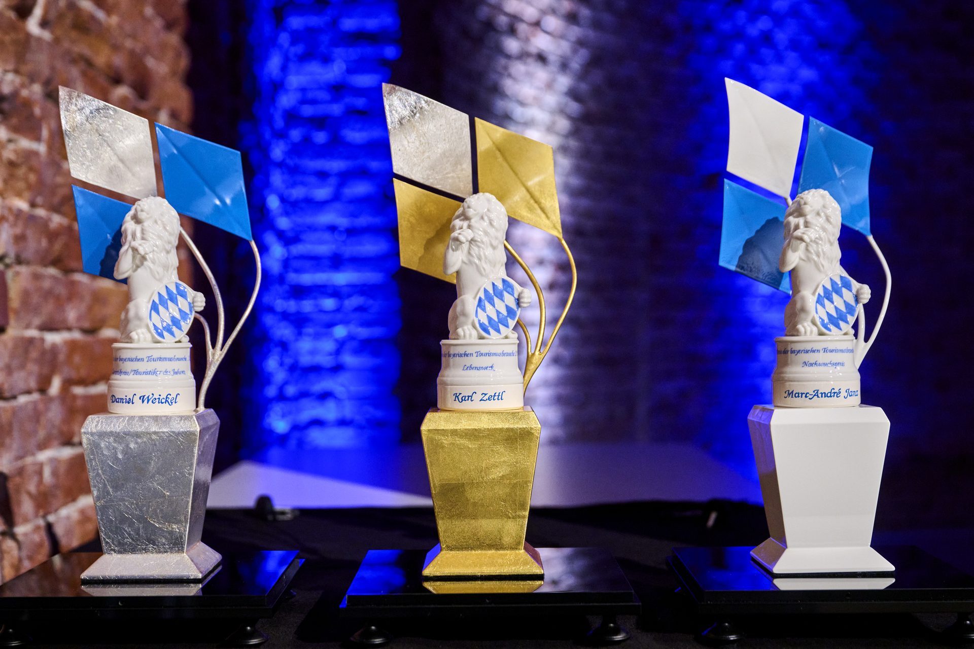 Drei Pokale in einem festlichen Umfeld, die f&uuml;r herausragende Leistungen in der bayerischen Tourismusbranche verliehen wurden.