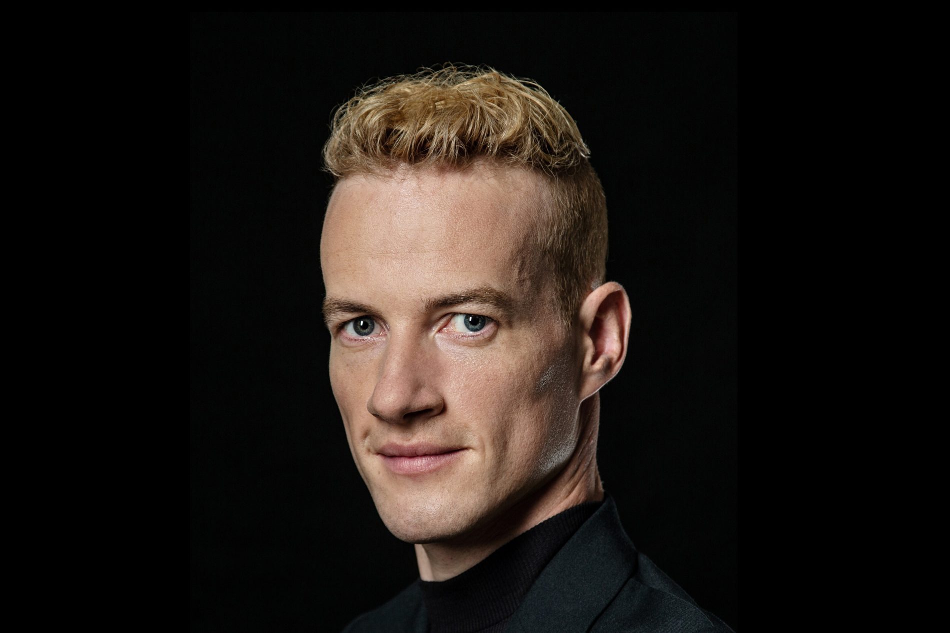 Janis McDavid vor schwarzem Hintergrund.